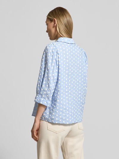 Frauenmodel trägt Regular Fit Bluse im Allover-Look Modell 'Bono' von LOLLYS LAUNDRY aus reiner Baumwolle, hellblau mit weißen Punkten, Hemdblusenkragen, Knopfleiste, 3/4-Arm, strukturierte Oberfläche, Rückenlänge 60 cm, Ärmellänge 38 cm, Ganzkörperansicht Rückansicht.