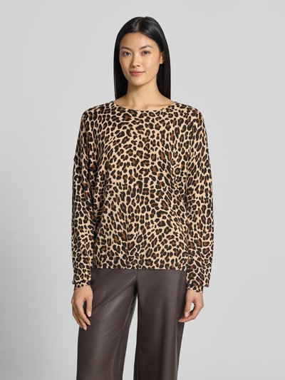Frauenmodel trägt Strickpullover im Allover-Look mit Rundhalsausschnitt von Apricot, beige-braunes Leopardenmuster, reine Baumwolle, Relaxed Fit, Ganzkörperansicht von vorne.