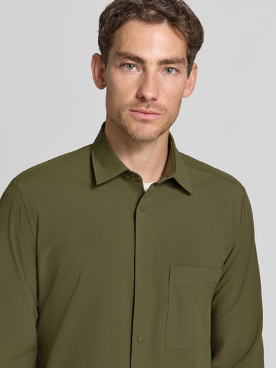 Männermodel trägt olivgrünes Relaxed Fit Freizeithemd mit Label-Patch Modell 'P-LEO-K-P-263' von BOSS, Nahaufnahme Oberkörper, Herren Hemdjacke.