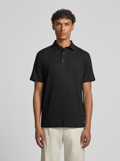 Männermodel trägt Slim Fit Poloshirt aus Leinen-Elasthan-Mix von OLYMP Level Five in Schwarz mit Knopfleiste, kurze Ärmel, Ganzkörperansicht von vorne.