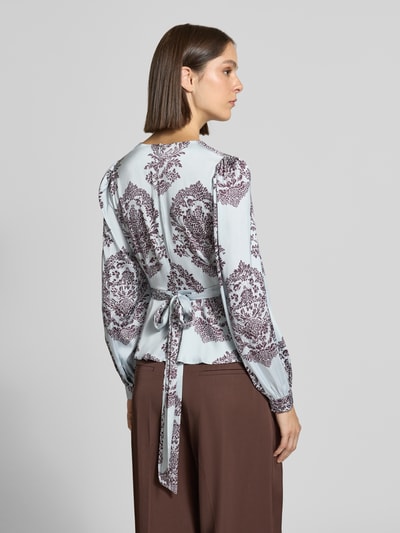 Vrouwenmodel draagt blouse met peplum-zoom Model 'Rista' van Neo Noir, getailleerde pasvorm, v-hals, met lange mouwen, ruglengte maat 36: 55 cm, mouwlengte maat 36: 65 cm, Ganzkörperansicht Rückansicht.
