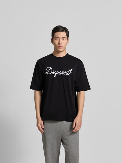 Männermodel trägt Loose Fit T-Shirt aus reiner Baumwolle von Dsquared2 in Schwarz mit Rundhalsausschnitt und Label-Stitching, Ganzkörperansicht von vorne.