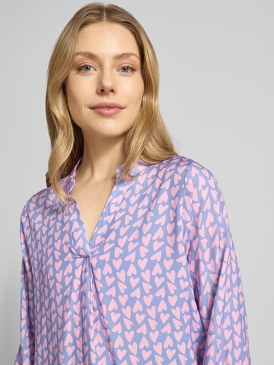 Frauenmodel trägt Bluse aus Viskose mit Serafino-Ausschnitt Modell 'Ja44nina' von ZABAIONE, Allover-Herzprint, lockerer Schnitt, Nahaufnahme Oberkörper.