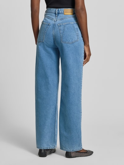 Frauenmodel trägt Loose-Fit Damen Jeans von Armedangels, Modell 'ENIJAA' aus Baumwoll-Denim in blauer Twill-Struktur, High-Waist, 5-Pocket-Design, Label-Patch, Ganzkörperansicht Rückansicht.