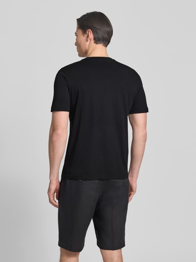 Männermodel trägt Regular Fit T-Shirt aus reiner Baumwolle Modell 'TE_BOARD' von BOSS Orange in Schwarz, unifarben, Kurzarm, Rückansicht Ganzkörperansicht.