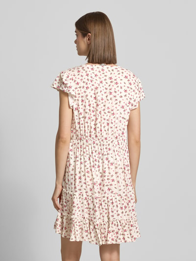 Frauenmodel trägt tailliertes Freizeitkleid aus reiner Viskose Modell 'CLAUDETTE' von Only mit Allover-Muster, Mini-Länge, Volantsaum, Webware, Ganzkörperansicht Rückansicht.