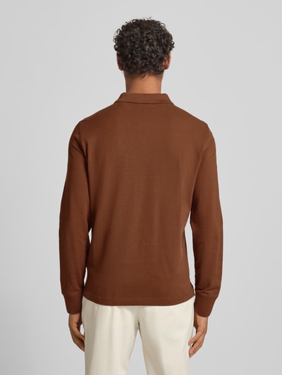 Männermodel trägt Regular Fit Poloshirt mit Label-Stitching von Gant in Braun, reine Baumwolle, Polokragen, Knopfleiste, Rückenlänge 68 cm, Ganzkörperansicht Rückansicht.