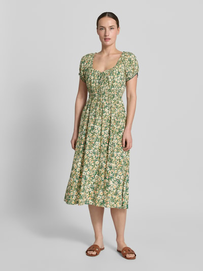 Frauenmodel trägt Midikleid aus Viskose mit Rüschenärmeln von Apricot, Taillierter Schnitt, Rundhalsausschnitt, Ganzkörperansicht von vorne.