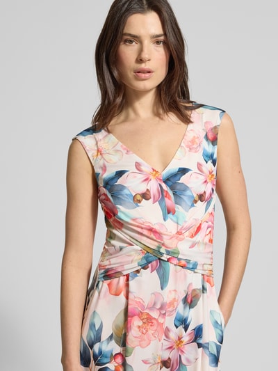 Modelka nosi Regular Fit Jumpsuit mit floralem Allover-Print von Vera Mont, elastyczna mieszanka materiałów, dekolt w serek, krój bez rękawów, nadruk na całej powierzchni w pastelowych kolorach, taliowany krój z marszczeniami, wszyty zamek błyskawiczny, całość o kobiecym i lekkim wyglądzie, całkowita długość 150 cm, długość tyłu 33 cm, szerokość w rozmiarze 36 to 43 cm, długość wewnętrzna nogawki 83 cm, widok: z przodu, zbliżenie na górną część ciała.