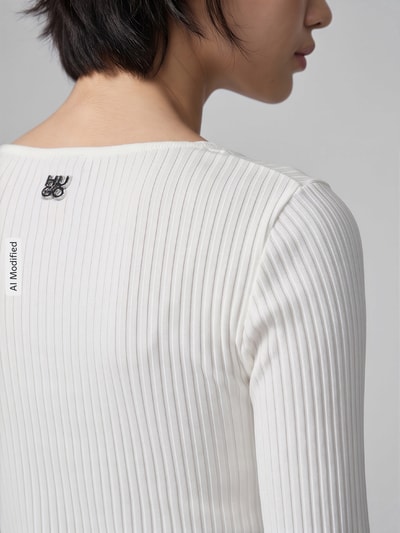 Frauenmodel trägt Slim Fit Langarmshirt aus Baumwoll-Mix Modell 'Dumille' von HUGO in Weiß mit Rippstrick-Struktur, Logo-Detail, Nahaufnahme Rückansicht, KI-modifiziertes Bild.