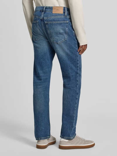 Männermodel trägt blaue Straight Fit Jeans aus Baumwoll-Mix Modell 'Bonito' von s.Oliver RED LABEL, mittelblaue Waschung, Tapered Fit, Ganzkörperansicht Rückansicht.