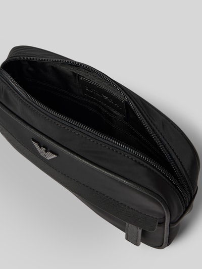 Produktfoto, Handtasche mit abnehmbarer Trageschlaufe von Emporio Armani in Schwarz, rechteckige Form, glatte Textur, Reißverschlüsse und Label-Applikation sichtbar, 25x14x6 cm, Schulterriemen 34 cm.