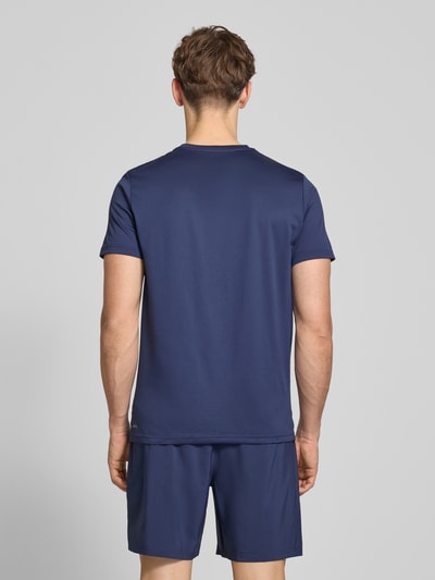 Männermodel trägt Regular Fit T-Shirt mit Logo-Print Modell 'Solid' von PUMA PERFORMANCE in Dunkelblau, glatte Textur, Ganzkörperansicht Rückansicht. Rückenlänge bei Größe M: 70 cm, Rundhalsausschnitt.