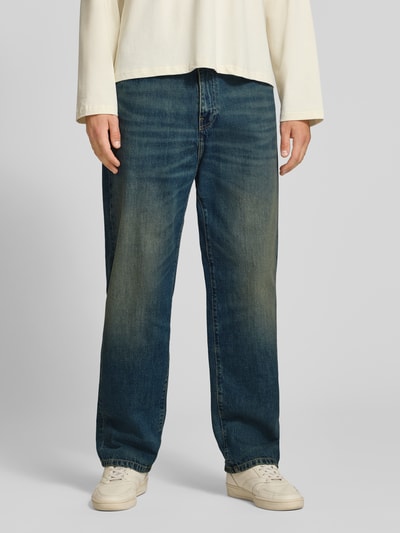 Männermodel trägt Straight Fit Jeans aus reiner Baumwolle Modell 'Aaron' von Carhartt Work In Progress in Dunkelblau, Nahaufnahme Unterkörper. 5-Pocket-Design, Knopf- und Reißverschluss, Bundweite 45 cm, Innenbeinlänge 77 cm.