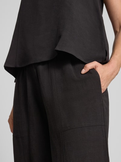 Vrouwenmodel draagt Relaxed Fit broek uit viscosemix model 'Myha' van OPUS, zwart, steekzakken, elastische band met tunnelkoord, detailopname heup.