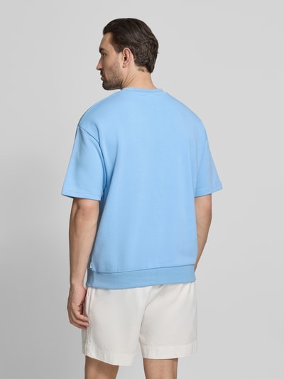Männermodel trägt Oversized T-Shirt mit Rundhalsausschnitt von Lindbergh aus Baumwoll-Mix mit Label-Detail, Rückenlänge 70 cm, Ganzkörperansicht Rückansicht.