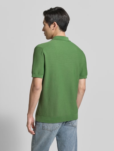 Männermodel trägt Regular Fit Poloshirt aus reiner Baumwolle von Lacoste, Optik: Unifarben, Kurzarm, Rumpfabschluss: gerippt, Ganzkörperansicht Rückansicht.