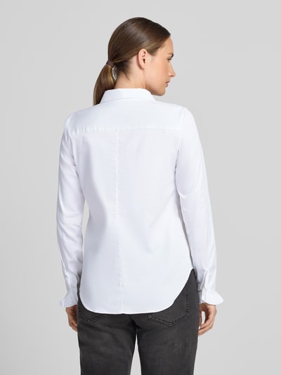 Männermodel trägt białą bluzkę koszulową z mieszanki bawełny od MOS MOSH, krój slim fit, kołnierzyk koszulowy, listwa guzikowa, falbany na zakończeniach rękawów, zaokrąglony dół, długość tyłu 70 cm w rozmiarze S, długość rękawów 62 cm w rozmiarze S, widok całej sylwetki z tyłu.