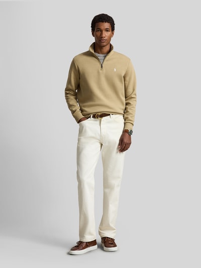 Männermodel trägt Relaxed Fit Troyer aus Baumwoll-Mix von Polo Ralph Lauren in Beige, kombiniert mit heller Hose, Ganzkörperansicht von vorne.