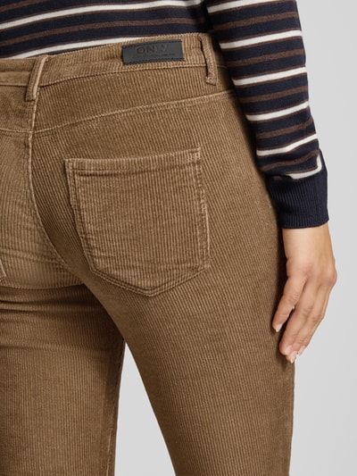 Frauenmodel trägt Fit and Flare Cordhose aus Baumwoll-Mix Modell 'MARY' von ONLY in brauner Farbe mit feiner Rippenstruktur, Nahaufnahme Rückansicht, Damen Cordhose von ONLY.