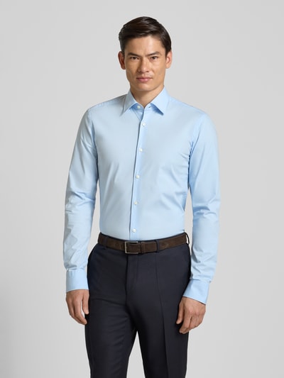 Männermodel trägt Slim Fit Businesshemd aus Baumwoll-Mix Modell 'H-HANK-KENT-C1-214' von BOSS in Hellblau, Ganzkörperansicht von vorne.