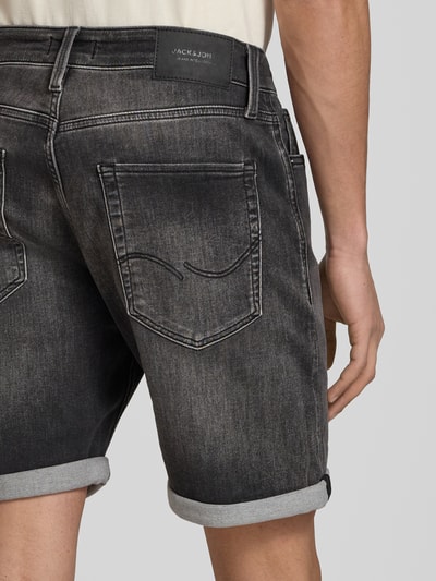 Männermodel trägt Regular Fit Jeansshorts mit Umschlag Modell 'RICK' von Jack & Jones im Used-Look, Baumwoll-Mix mit Stretch-Anteil, Detailaufnahme Rückenansicht.