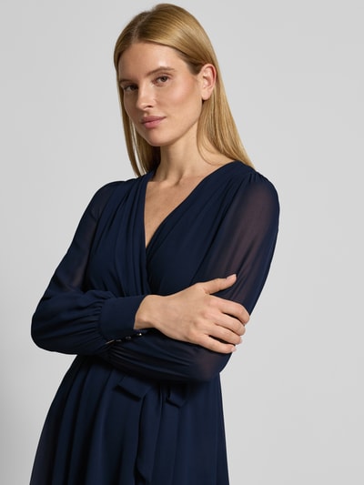 Frauenmodel trägt Regular Fit Midikleid mit Taillenband von Christian Berg Cocktail in Dunkelblau, Chiffon mit Falten-Optik, Nahaufnahme Oberkörper.