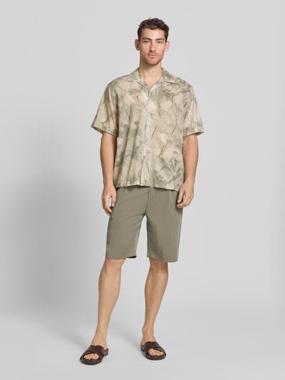 Männermodel trägt Relaxed Fit Freizeithemd aus Bio-Baumwoll-Modal-Mix Modell 'RELAXAIR' von SELECTED HOMME, Optik: Unifarben, Passform: Relaxed Fit, Hemdkragen: Reverskragen, durchgehende Knopfleiste, Ärmelform: Kurzarm, Material: Bio-Baumwoll-Modal-Mix, Ganzkörperansicht von vorne.