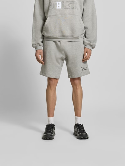 Männermodel trägt Sweatshorts aus Baumwoll-Mix von RHUDE in Grau mit Gerade Passform, elastischem Bund mit Tunnelzug, Label-Stitching, Eingrifftaschen, Ganzkörperansicht von vorne. Innenbeinlänge 25 cm, Bundweite 38 cm bei Größe M.