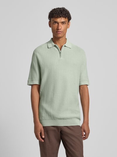 Männermodel trägt Regular Fit Poloshirt aus reiner Bio-Baumwolle Modell 'CRAN' von SELECTED HOMME in Strickoptik, Ganzkörperansicht von vorne.