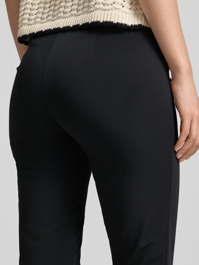 Vrouwenmodel draagt zwarte stoffen broek, slim fit, model 'SABRINA' van SEDUCTIVE, materiaalmix met katoen, detailopname achterkant.