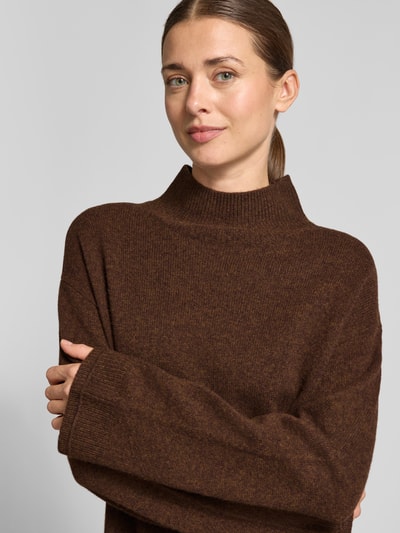 Frauenmodel trägt Knielanges Kleid aus reiner Baumwolle von Christian Berg Woman in Strick-Optik, braune Farbe, Nahaufnahme Oberkörper. Regular Fit, langärmlig, Rückenlänge 97 cm, Brustweite 56 cm, Ärmellänge 56 cm.