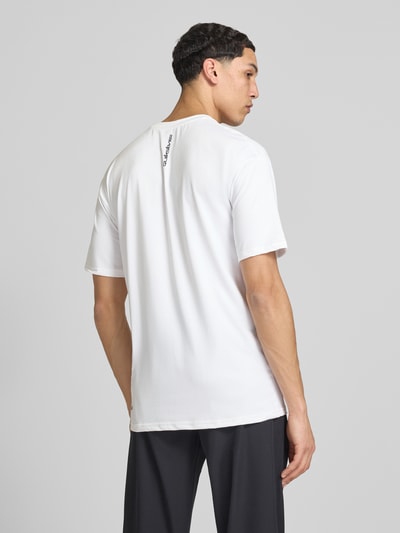 Männermodel trägt T-Shirt mit Rundhalsausschnitt und Logo von Quiksilver, weiß, Material-Mix mit Stretch-Anteil, Regular-Fit, Rückenlänge 75 cm, Ganzkörperansicht Rückansicht.