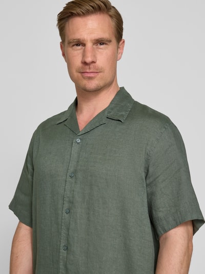 Mannelijk model draagt Relaxed Fit Leinenhemd met Resortkraag Modell 'KYLIAN' van SELECTED HOMME, effen groen linnen, korte mouwen, doorlopende knoopsluiting, rugpas, pure linnen, close-up bovenlichaam.