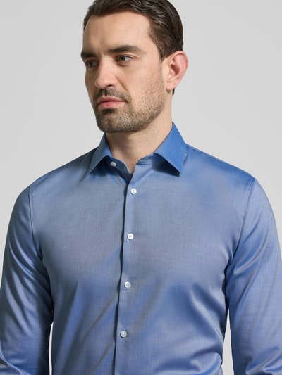 Männermodel trägt Super Slim Fit Business-Hemd mit Kentkragen und Strukturmuster von OLYMP, Baumwoll-Elasthan-Mix, Nahaufnahme Oberkörper.