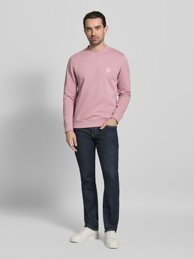 Männermodel trägt Regular Fit Sweatshirt aus reiner Baumwolle Modell 'WESTART' von BOSS Orange in Unifarben mit Label-Stitching, Ganzkörperansicht von vorne
