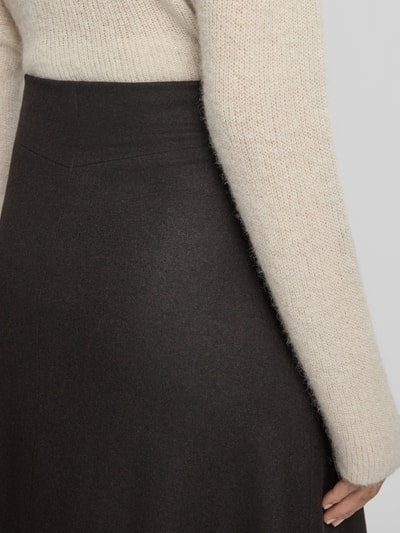 Frauenmodel trägt Maxirock mit Viskose-Woll-Anteil von Rich & Royal, dunkle Farbe, feine Struktur, Nahaufnahme Oberkörper, Detailaufnahme Bund. Elastischer Material-Mix, leichte A-Linie, Maxilänge, elastischer Bund.
