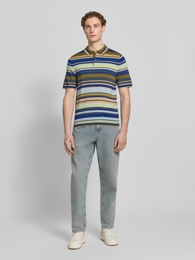 Männermodel trägt Slim Fit Poloshirt aus reiner Wolle in Strick-Optik von PAUL SMITH, bunt gestreift, Polokragen, Kurzärmelig, Ganzkörperansicht von vorne.