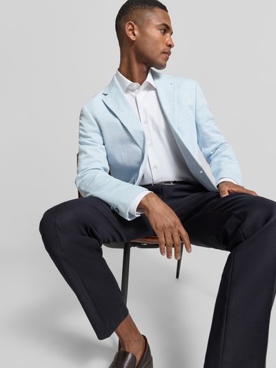 Męski model nosi Slim Fit 2-Knopf-Sakko mit Pattentaschen von MCNEAL, mieszanka bawełny, fakturowany wzór, kołnierz z połami, kieszenie z patką, długość tyłu w rozmiarze 50: 75 cm, szerokość w rozmiarze 50: 45 cm, długość rękawów w rozmiarze 50: 65 cm, jasnoniebieski i granatowy, gładka faktura, widok całej sylwetki z przodu.