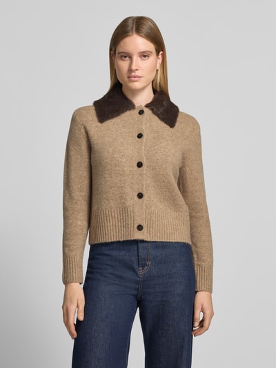 Kobiece model prezentuje Strickjacke aus Wollmix mit Webpelzkragen Modell 'Dofur' od OPUS w melanżowym, dzianinowym wzorze, długi rękaw, ściągacze na rękawach i dole, kołnierz wykładany, pełna listwa guzikowa, wełniany miks; ujęcie całej sylwetki z przodu.