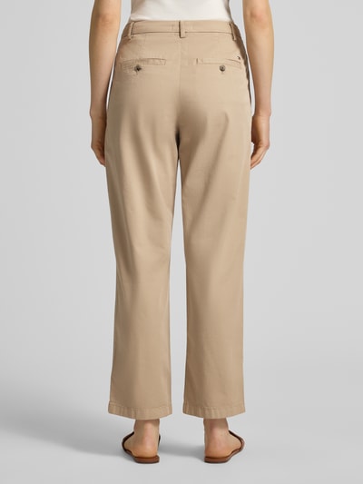 Kobiece model nosi Slim Fit Chino aus Baumwoll-Mix od Tommy Hilfiger, efekt: jednolity kolor, krój slim fit, mieszanka bawełny, wpuszczane kieszenie z boku i kieszenie z tyłu, szlufki na pasek, zapięcie na guzik i ukryty zamek błyskawiczny, widok całej sylwetki z tyłu.