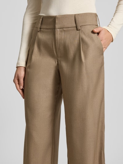 Frauenmodel trägt Stoffhose mit Gesäßtasche von Gina Tricot, Material-Mix mit Viskose-Anteil, lockerer Schnitt, französische Eingrifftaschen, Nahaufnahme Oberkörper.