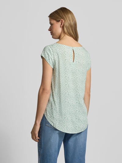 Kobiece modelka nosi Regular Fit Blusenshirt aus reiner Viskose Modell 'NOVA' od Only, jasnozielony z białym wzorem, krótki rękaw, dekolt okrągły, zaokrąglony dół, detal z tyłu, krój regular fit, tylny wycięcie typu łezka, widok całej sylwetki z tyłu.