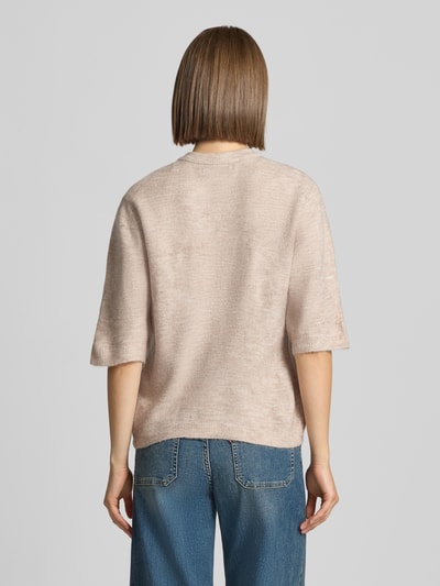 Frauenmodel trägt Regular Fit Strickjacke mit Schnürung Modell 'SIMONI' von ONLY in hellem Beige, kombiniert mit blauer Jeans, Ganzkörperansicht Rückansicht, Damen Strickjacke von ONLY.