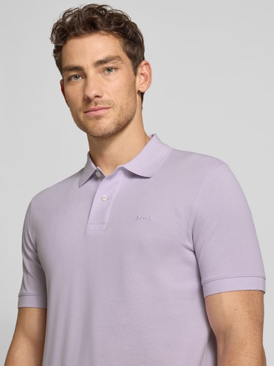 Männermodel trägt Regular Fit Poloshirt aus reiner Baumwolle Modell 'PALLAS' von BOSS in Optik: Unifarben, Nahaufnahme Oberkörper.