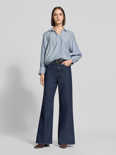 Vrouwenmodel draagt Relaxed Fit blouse uit viscosemix van zero, platte kraag, met lange mouwen, ruglengte maat 36: 66 cm, mouwlengte 59 cm, lichtblauw met gestreept design, combinatie van gladde stof en subtiele glans, effen donkere jeans, Ganzkörperansicht van voren.