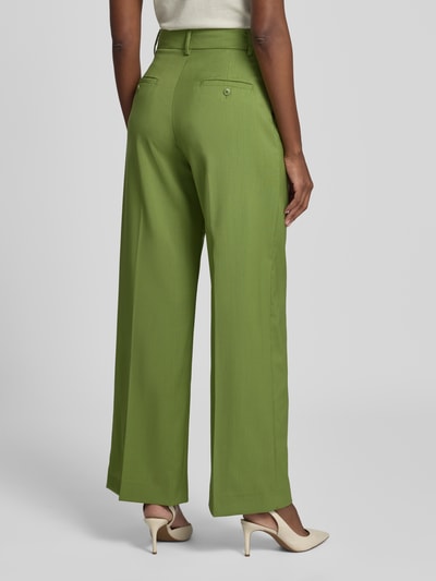 Männermodel trägt zielone szerokie spodnie z żywej wełny Weekend Max Mara Weite Hose aus reiner Schurwolle Modell 'WKDVISIVO', Ganzkörperansicht Rückansicht.
