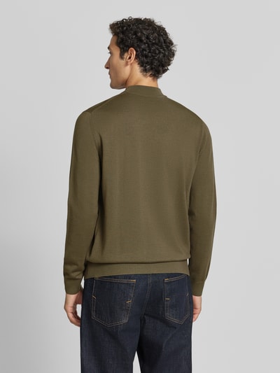 Männermodel trägt Regular Fit Pullover aus reiner Schurwolle Modell 'Davide' von JOOP! COLLECTION in Olivgrün, Ganzkörperansicht Rückansicht.
