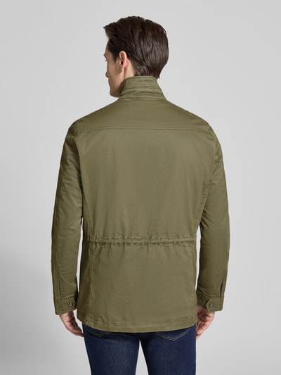 Männermodel trägt Jacke mit Stehkragen und Pattentaschen von Christian Berg Men aus Baumwoll-Elasthan-Mix in Oliv, Regular-Fit, Ganzkörperansicht Rückansicht.