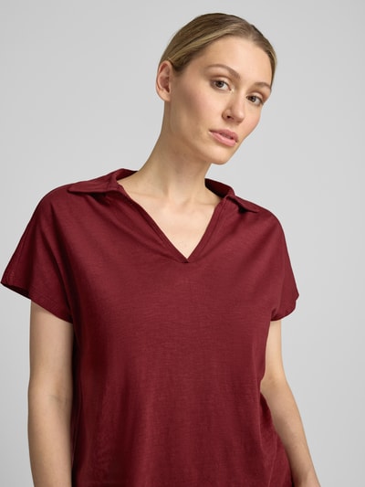 Frauenmodel trägt Regular Fit Poloshirt aus reiner Baumwolle von s.Oliver RED LABEL in Dunkelrot, glatte Textur, Nahaufnahme Oberkörper.